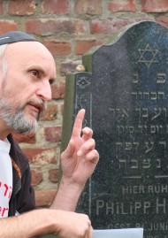 Ein Grabstein mit hebräischer Inschrift wird erläutert.
