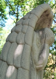 Statue eines Engels, der sich weinend die Hände vor sein Gesicht hält.