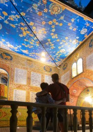 Zwei Personen stehen in der beleuchteten Synagoge mit blauer Decke